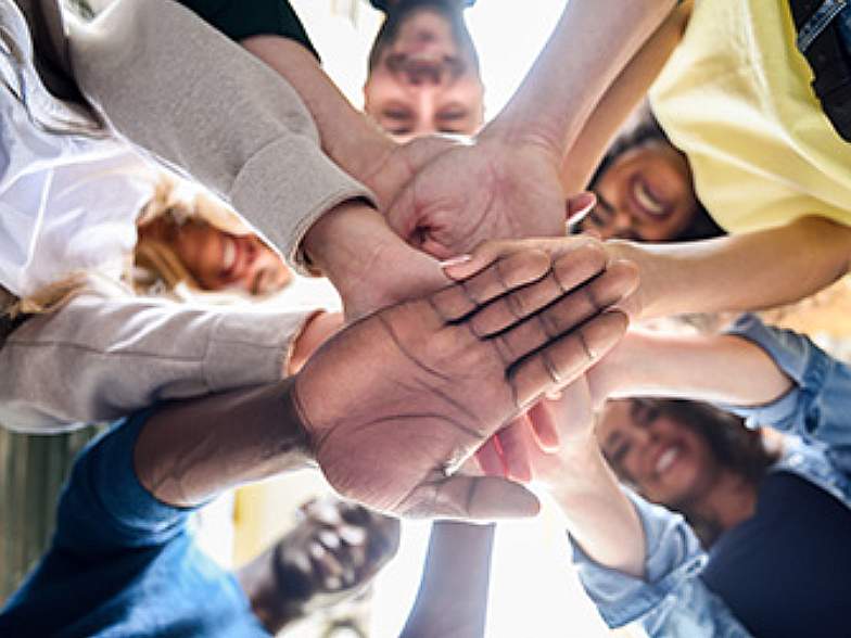 Pictured: A diverse group of young people join hands